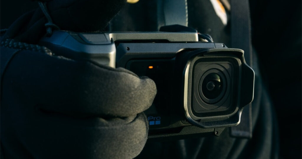 A professional filmmaker using the GoPro Mission 1 features by mounting it on a specialized cinema cage rig.