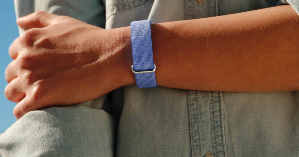 A close-up of the Fitbit Air pebble being inserted into a Performance Loop band.