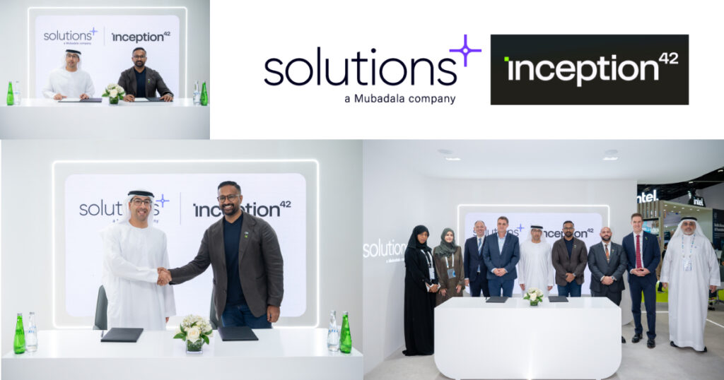 Two business leaders shake hands on stage at an Abu Dhabi AI expo after signing an agreement