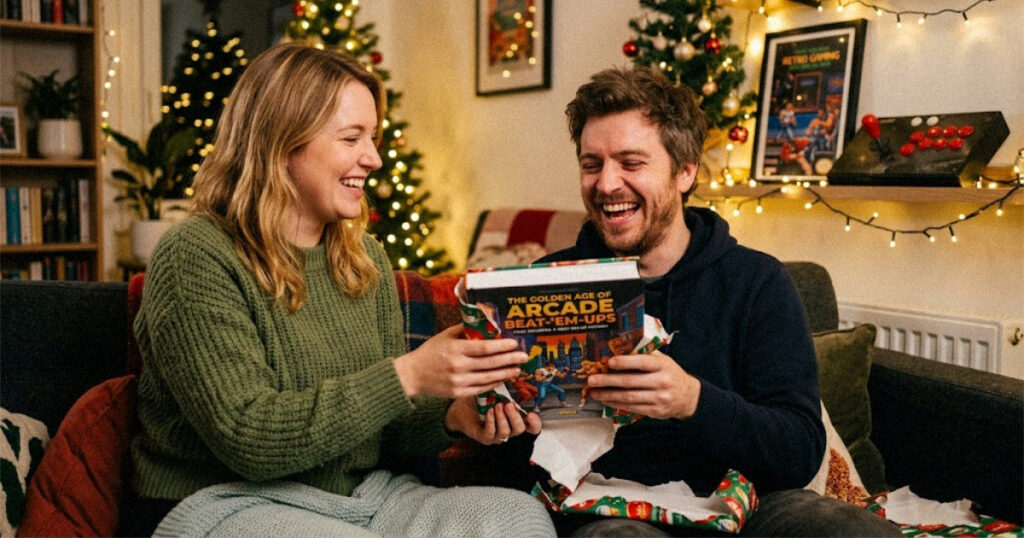 Man laughing as he opens a wrapped retro video game book as a gift